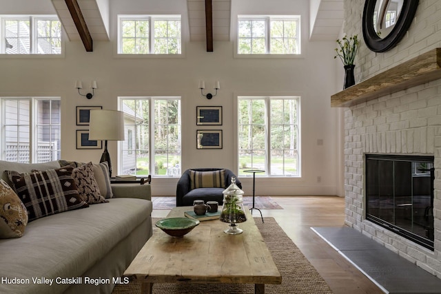 245 Brown Rd, Olivebridge, NY 12461 - living room featuring a high ceiling, healthy amount of natural light, beam ceiling, wood finished floors, and a brick fireplace
