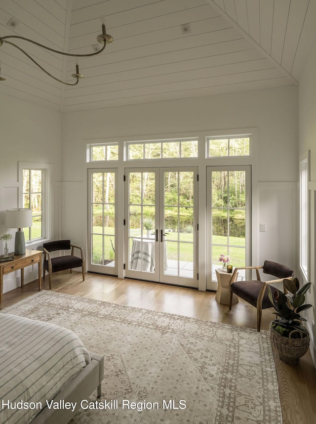 245 Brown Rd, Olivebridge, NY 12461 - bedroom featuring access to exterior, wood finished floors, high vaulted ceiling, french doors, and a decorative wall