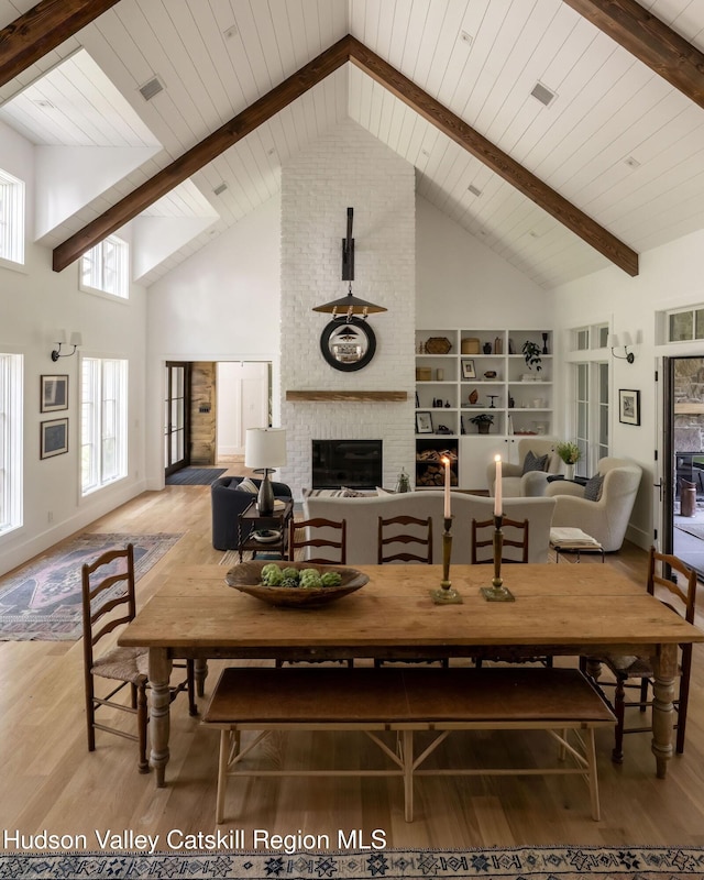 245 Brown Rd, Olivebridge, NY 12461 - dining room featuring high vaulted ceiling, wood finished floors, a fireplace, a ceiling fan, and a wooden ceiling with exposed beams