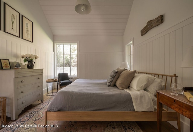 245 Brown Rd, Olivebridge, NY 12461 - bedroom with lofted ceiling, wainscoting, a decorative wall, and wood finished floors