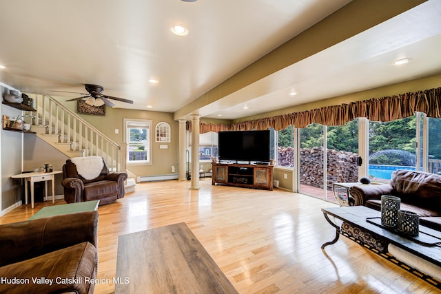 2-6 Old Firehouse Rd, Plattekill, NY 12568 - living room with decorative columns, light wood-style flooring, ceiling fan, a baseboard heating unit, and stairs
