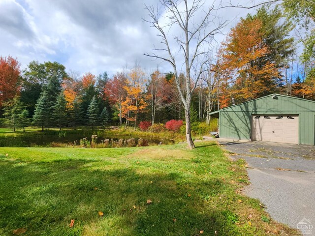 159 Toles Hollow Rd, Conesville, NY 12076 - view of green lawn featuring driveway, a garage, and an outbuilding