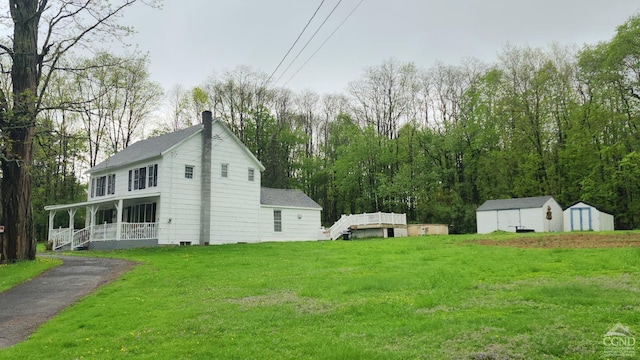 287 Shady Glen Rd, East Durham, NY 12423 - view of green lawn featuring a storage unit, a porch, and an outbuilding