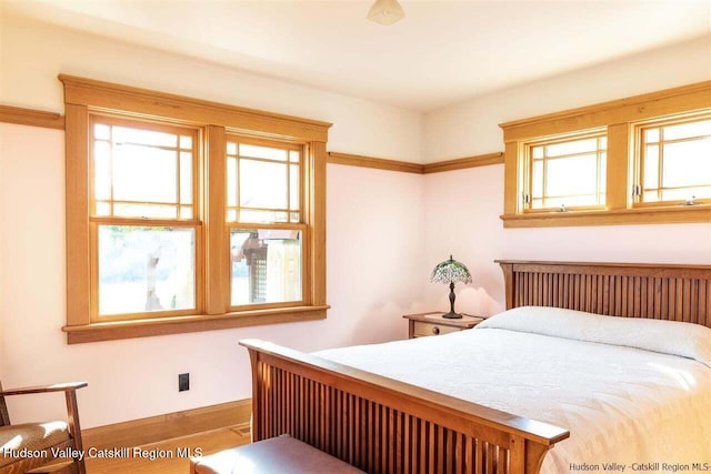 bedroom featuring baseboards and wood finished floors