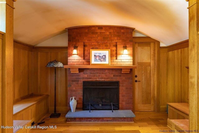 interior details with wooden walls, a fireplace, and wood finished floors