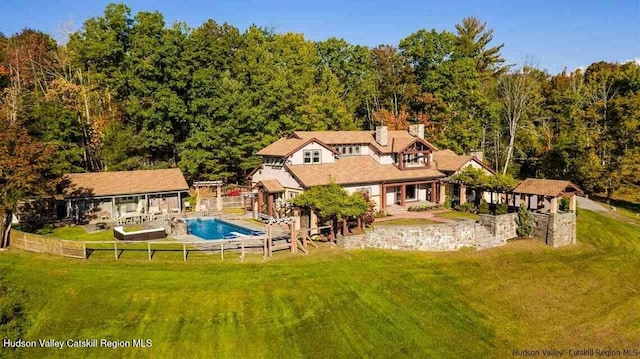 outdoor pool featuring a yard, a gazebo, a view of trees, and a fenced backyard