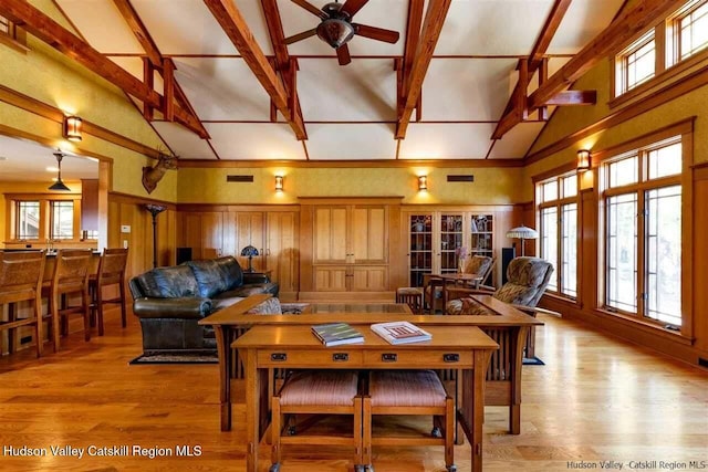 living area with visible vents, light wood-style flooring, a ceiling fan, and high vaulted ceiling
