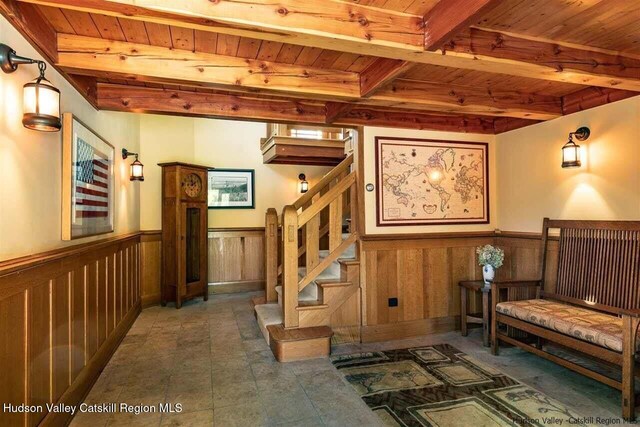 interior space featuring wainscoting, beam ceiling, and wood ceiling