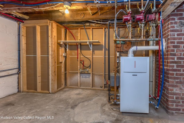 unfinished below grade area with concrete block wall and a heating unit