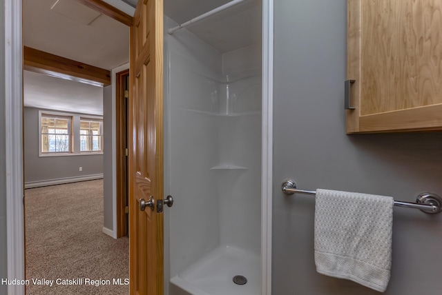 bathroom with a stall shower, baseboards, and baseboard heating