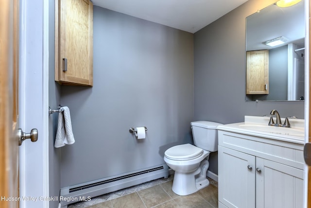 bathroom with baseboards, toilet, tile patterned flooring, vanity, and a baseboard heating unit