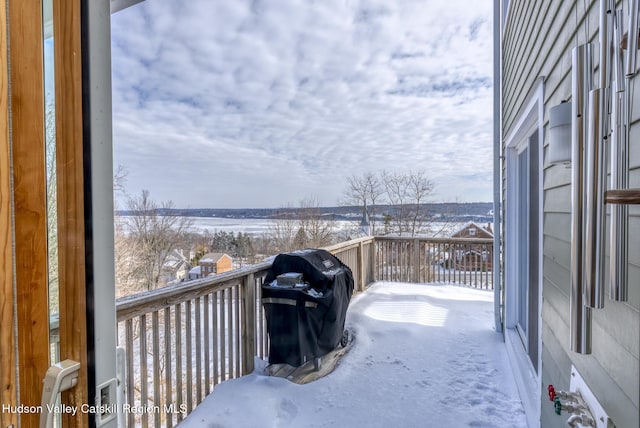 snow covered back of property with a grill