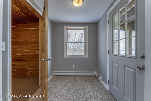 doorway with a baseboard heating unit, carpet flooring, and baseboards