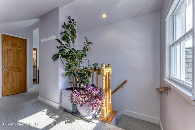 interior space featuring a wealth of natural light, baseboards, carpet flooring, and an upstairs landing