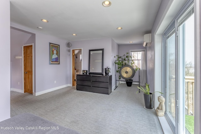 interior space with recessed lighting, a wall mounted air conditioner, carpet flooring, and baseboards