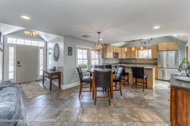 dining area featuring lofted ceiling, baseboards, a notable chandelier, and recessed lighting