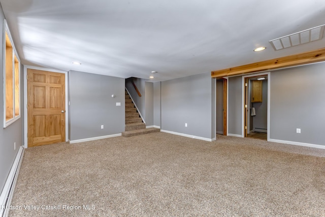 finished below grade area with a baseboard heating unit, carpet floors, stairway, and visible vents