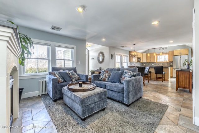 living room featuring a wealth of natural light, radiator, visible vents, and recessed lighting