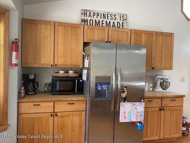 87 Dock St, Saugerties, NY 12477 - kitchen with stainless steel fridge with ice dispenser, black microwave, and light countertops