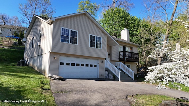 87 Dock St, Saugerties, NY 12477 - view of front of house with a garage, asphalt driveway, central air condition unit, a chimney, and stairway
