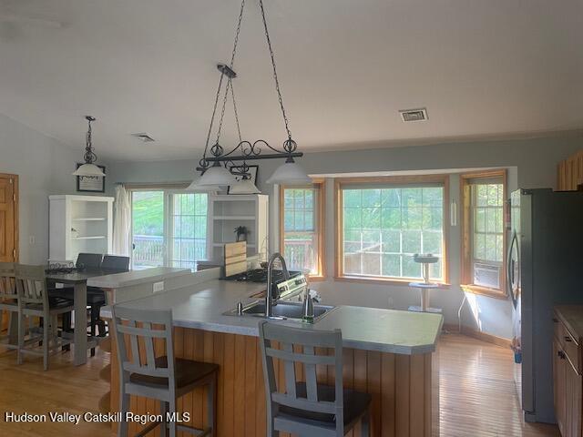 87 Dock St, Saugerties, NY 12477 - kitchen with freestanding refrigerator, a sink, an island with sink, light wood-style flooring, and light countertops