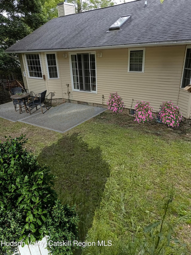 87 Dock St, Saugerties, NY 12477 - rear view of property featuring a chimney, a lawn, a shingled roof, and a patio