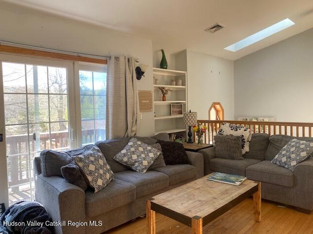 87 Dock St, Saugerties, NY 12477 - living room featuring a skylight, light wood-type flooring, and vaulted ceiling