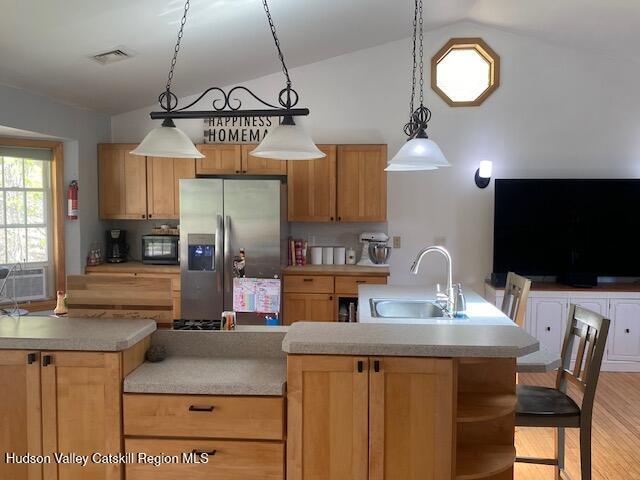 87 Dock St, Saugerties, NY 12477 - kitchen featuring stainless steel fridge, a sink, lofted ceiling, black microwave, and light countertops