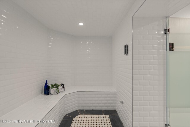 bathroom featuring tile patterned flooring and an enclosed shower