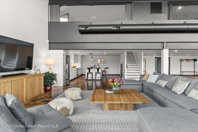 living room with a high ceiling and dark hardwood / wood-style floors