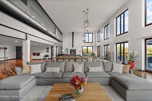 living room with hardwood / wood-style floors, a fireplace, and a high ceiling