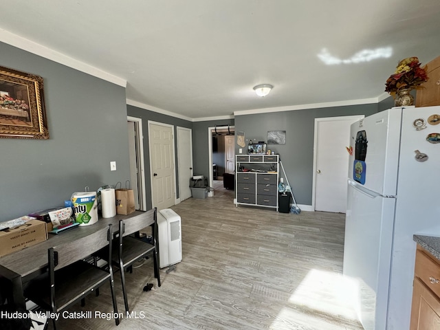 office space featuring light wood-type flooring, baseboards, and crown molding