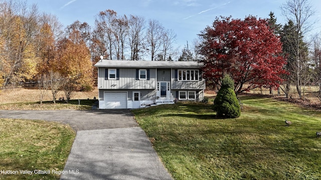 bi-level home with a front yard, driveway, and an attached garage