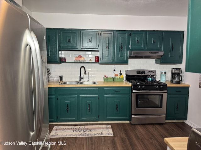 kitchen featuring dark wood-style floors, light countertops, appliances with stainless steel finishes, a sink, and under cabinet range hood