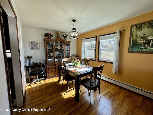 dining room with a baseboard radiator and wood finished floors