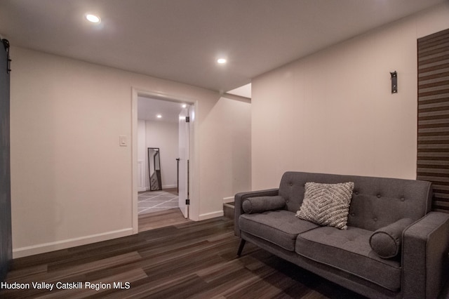 living room featuring dark wood-type flooring and a barn door