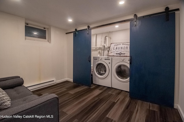 washroom featuring a barn door, dark wood-type flooring, washing machine and clothes dryer, and baseboard heating