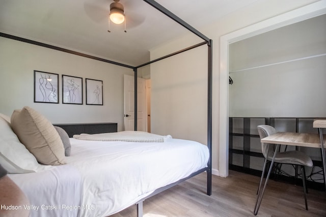 bedroom with crown molding, ceiling fan, and hardwood / wood-style floors