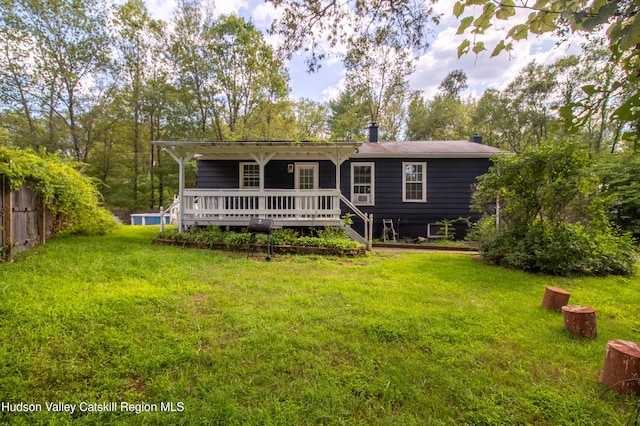 back of property with a wooden deck and a lawn