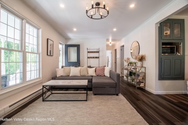 living room featuring ornamental molding, dark wood-type flooring, an inviting chandelier, and baseboard heating