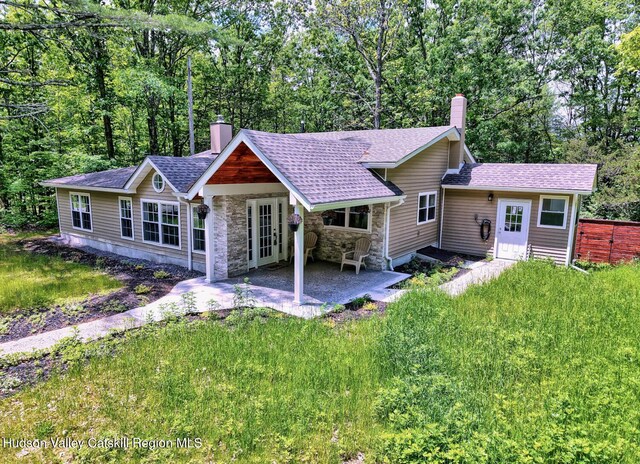 534 Rte 145, Cairo, NY 12413 - view of front of house featuring a chimney, stone siding, a patio area, a shingled roof, and a front yard