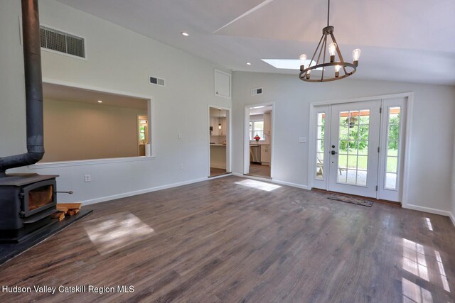 534 Rte 145, Cairo, NY 12413 - unfurnished living room with a wood stove, lofted ceiling, a chandelier, dark wood finished floors, and baseboards