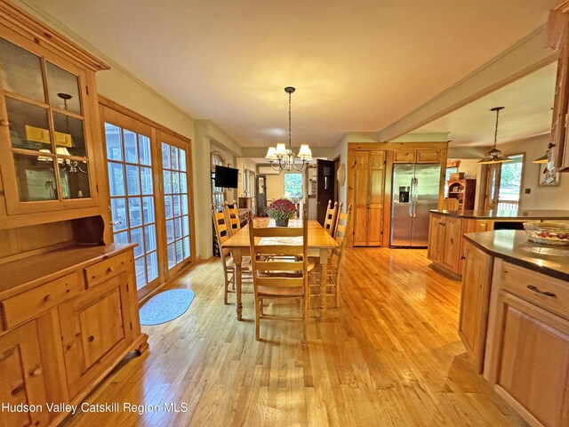 dining room featuring light wood-type flooring and an inviting chandelier