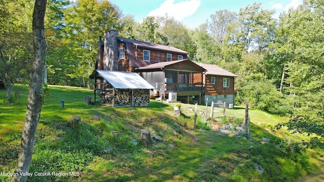 back of property featuring a yard and a wooden deck