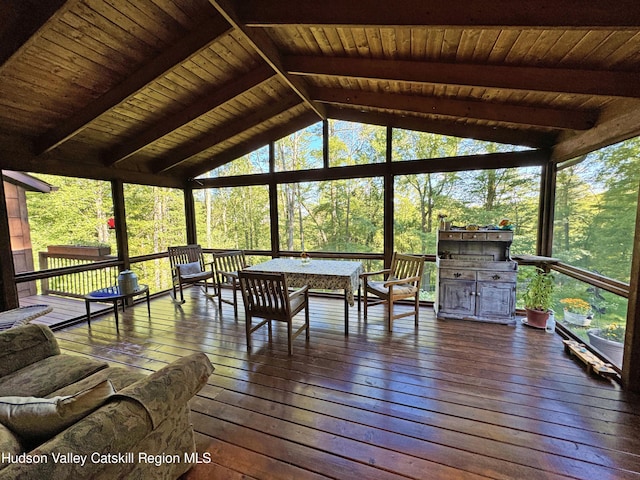 sunroom with lofted ceiling with beams, plenty of natural light, and wooden ceiling