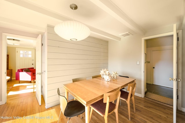 592 County Route 6, High Falls, NY 12440 - dining area featuring wood walls, visible vents, light wood finished floors, baseboards, and beam ceiling