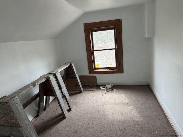 additional living space with light colored carpet and lofted ceiling