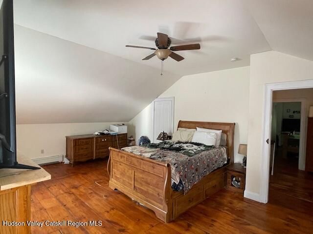 bedroom featuring lofted ceiling, wood-type flooring, and a ceiling fan