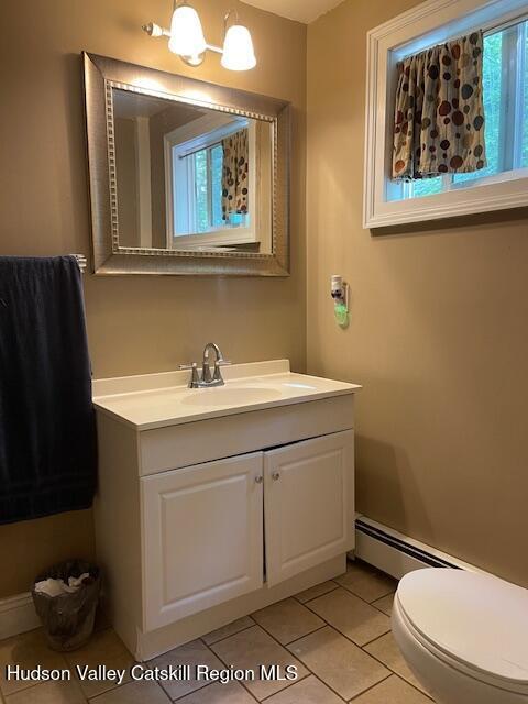 bathroom featuring vanity, tile patterned floors, toilet, and baseboard heating