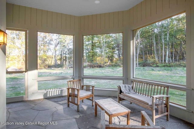 sunroom / solarium with stone tile floors and radiator
